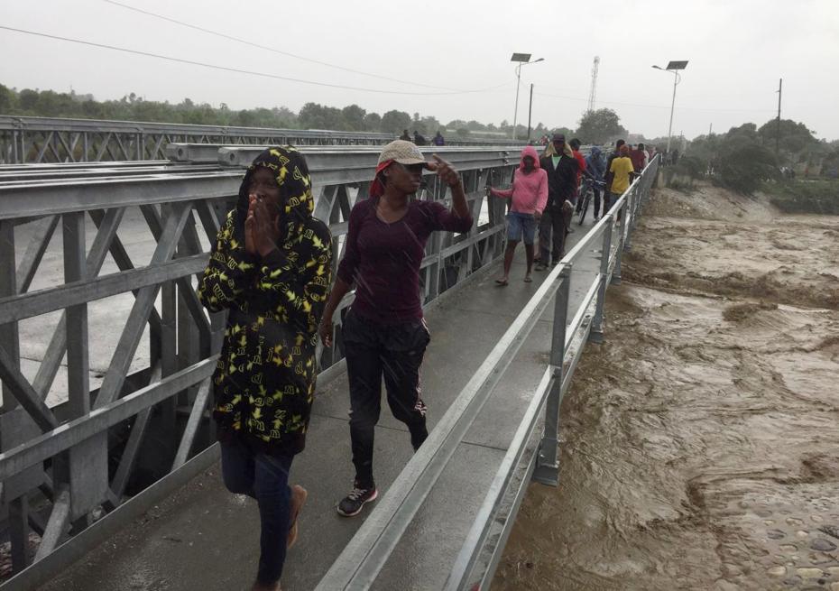 People cross a bridge while Hurricane Matthew passes in Port-au-Prince, Haiti, October 4, 2016. REUTERS/Carlos Garcia Rawlins TPX IMAGES OF THE DAY - RTSQRHE