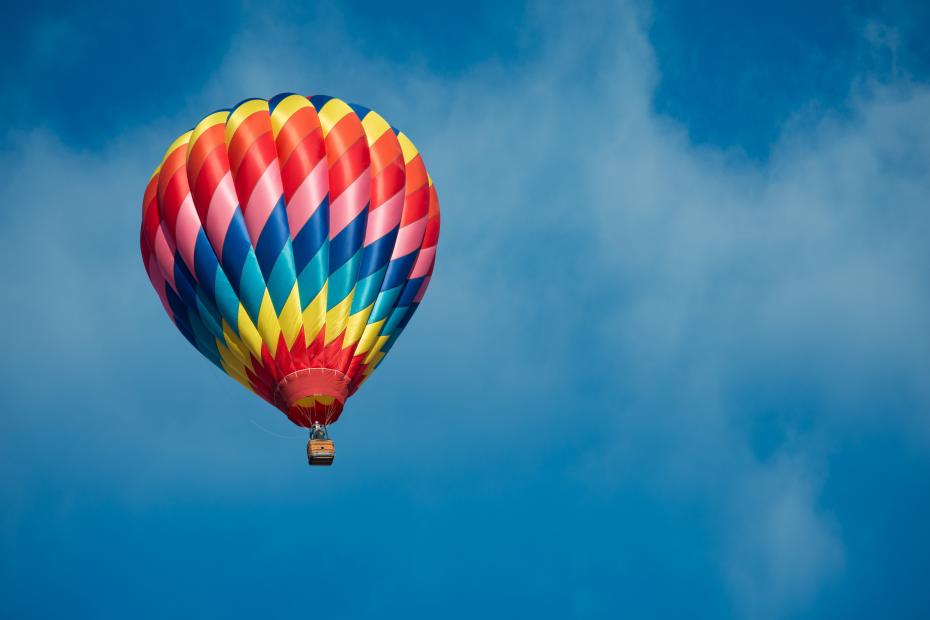 A brightly colored hot air balloon with a sky blue background