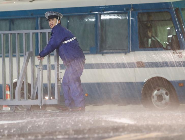 A policeman stands guard in the heavy rain outside the headquarters of Japan's ruling Liberal Democratic Party (LDP) in Tokyo