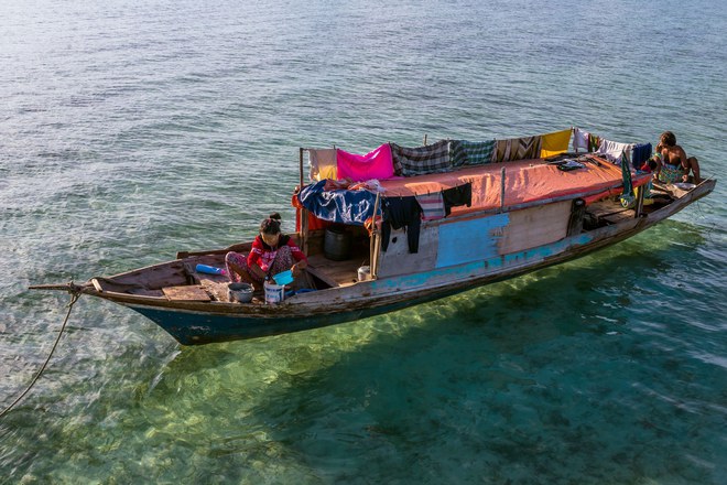 Pic by Claudio Sieber/Caters News - (Pictured: Sea Bajau who live within a basic setup on their handmade houseboats (called lepa lepa) 30/05/2017.) - THESE fascinating images reveal what life is like for the Bajau people - a nomadic tribe who spend their lives on the water. The group have been dubbed sea gypsies thanks to the fact they continue to live a seaborne lifestyle.The striking images - taken by photographer Claudio Sieber - show youngsters out catching fish in long narrow canoes. He took the pictures off the coast of Borneo where the Bajau are able to dive up to 20 metres without the use of modern scuba gear.They even reportedly experience land sickness when they leave the water. SEE CATERS COPY.