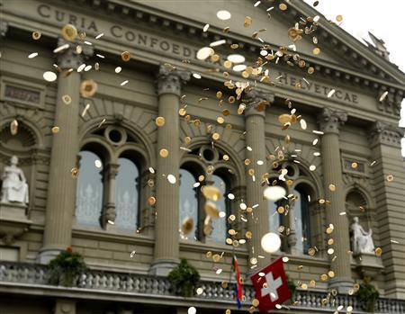 Five cent coins are pictured in the air in front of the Federal Palace during an event organised by the Committee for the initiative Grundeinkommen in Bern