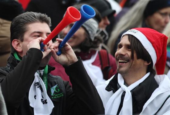 A protester blows into horns during a demonstration in Vienna