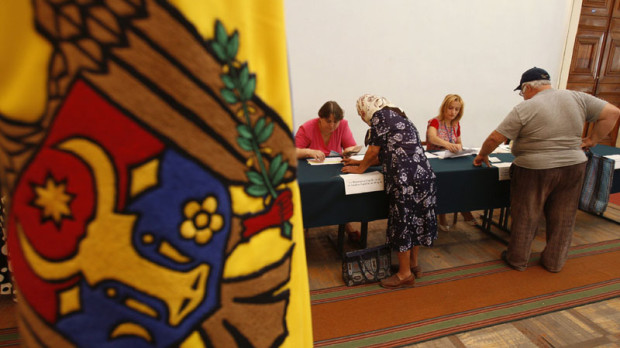 Moldovan citizens wait to cast their ballots at a polling station in Chisinau