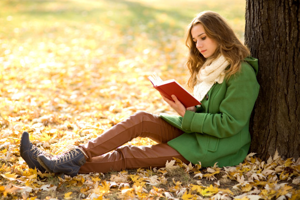 Girl reading book outdoors