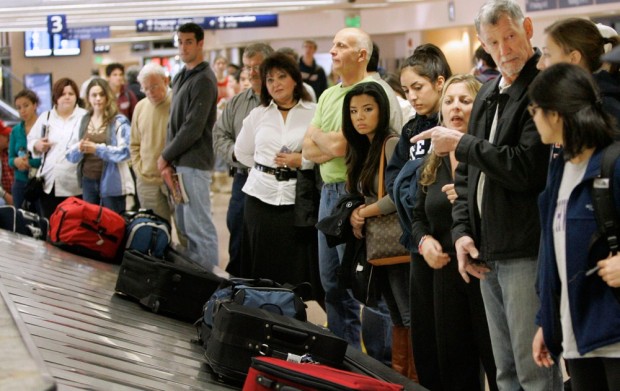 Image: Travelers line up to get their luggage