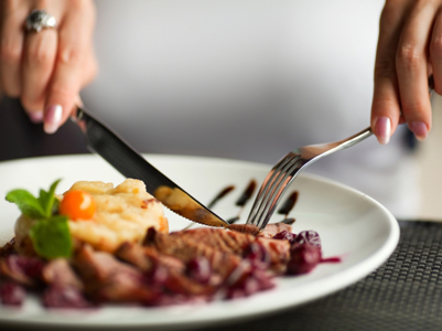 Female hands with a dinner at restaurant.