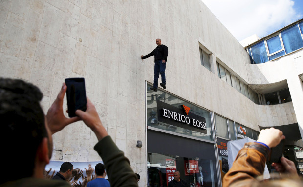 Onlookers take pictures of purported levitation trick in Tel Aviv