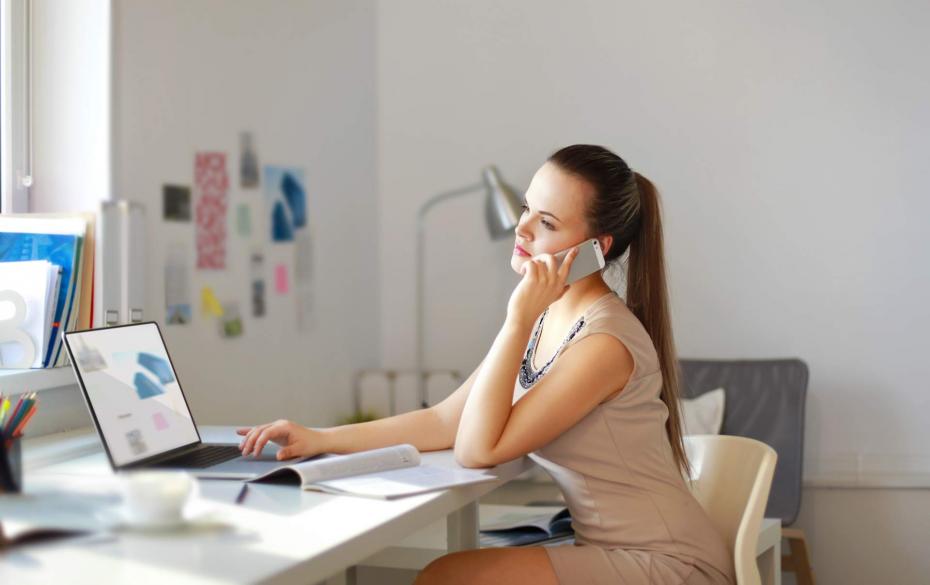 Happy-office-girl-at-desk-working-on-laptop