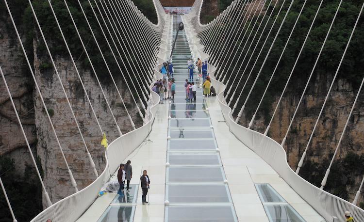 People wait for a safety test ceremony of a 430-meter-long glass-bottom bridge in Zhangjiajie