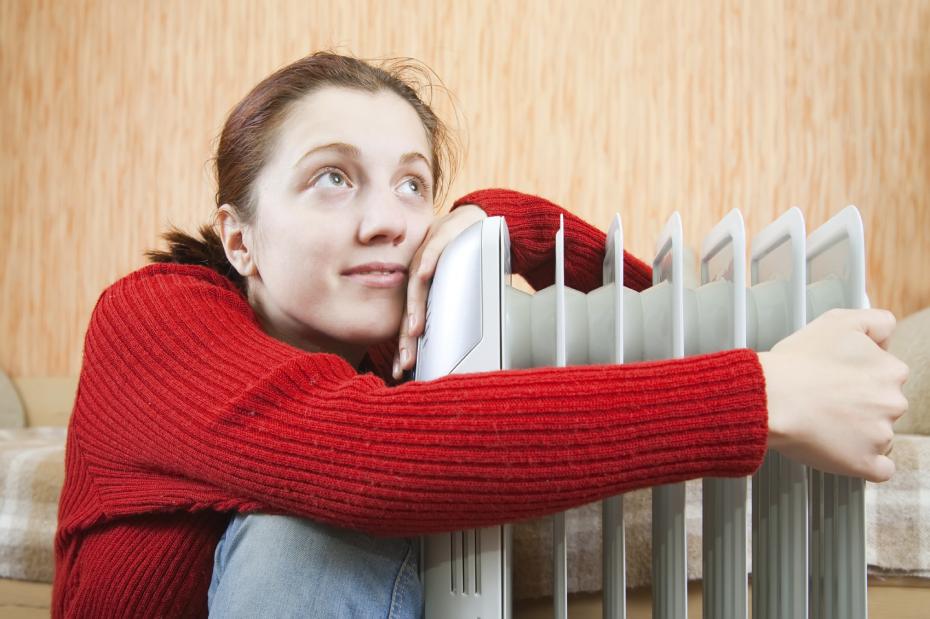 girl is sitting near oil heater