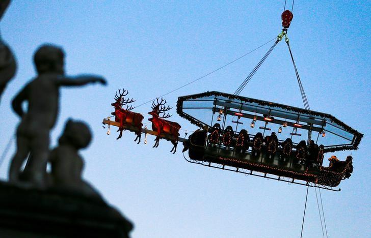 Guests enjoy dinner at the table „Santa in the sky”, lifted by a crane and decorated to match the appearance of a „Santa Sleigh” as part as the Christmas festivities, in Brussels