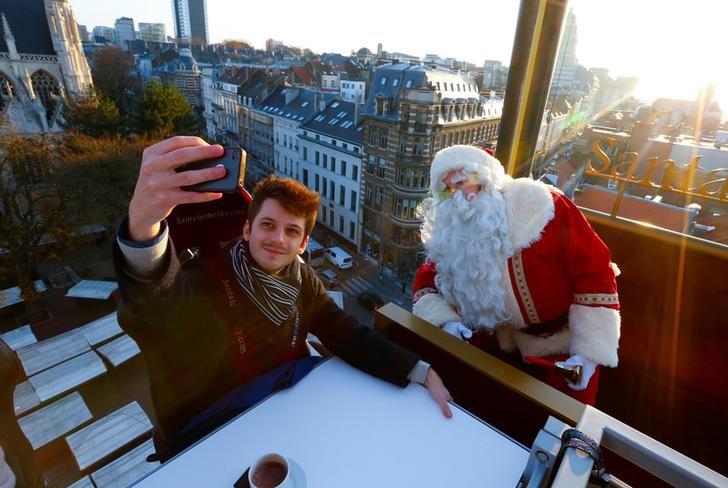 Guests enjoy dinner at the table "Santa in the sky", lifted by a crane and decorated to match the appearance of a "Santa Sleigh" as part as the Christmas festivities, in Brussels