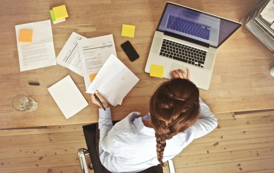 Businesswoman Working At Her Office Desk With Documents And Laptop