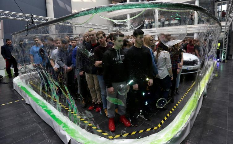 275 participants and a car stand inside a soap bubble to achieve the Guinness World Record for the most people surrounded by a soap bubble in Mlada Boleslav