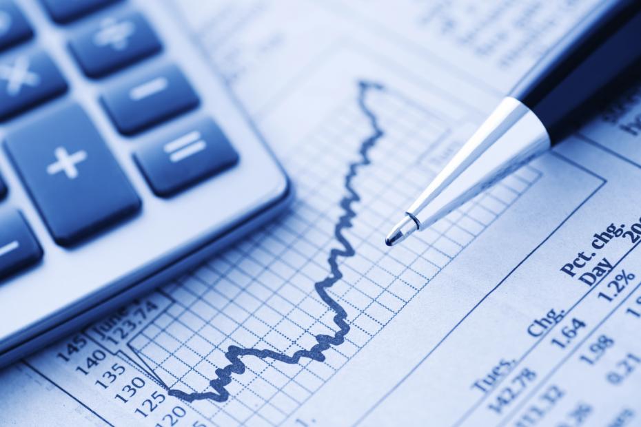 Close-up of a Calculator and Pen on a Financial Newspaper.  Blue-toned.