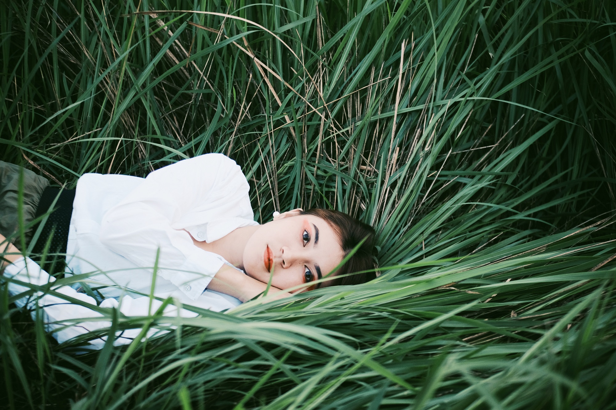 woman-lying-down-on-blades-of-grass-3099025