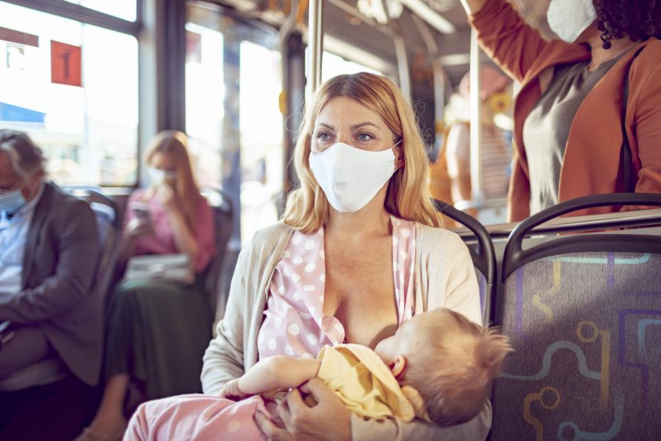 Mother breastfeeding her baby while commuting on a bus