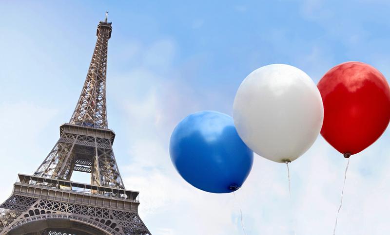 Balloons in the colors of the French flag in front of the Eiffel Tower