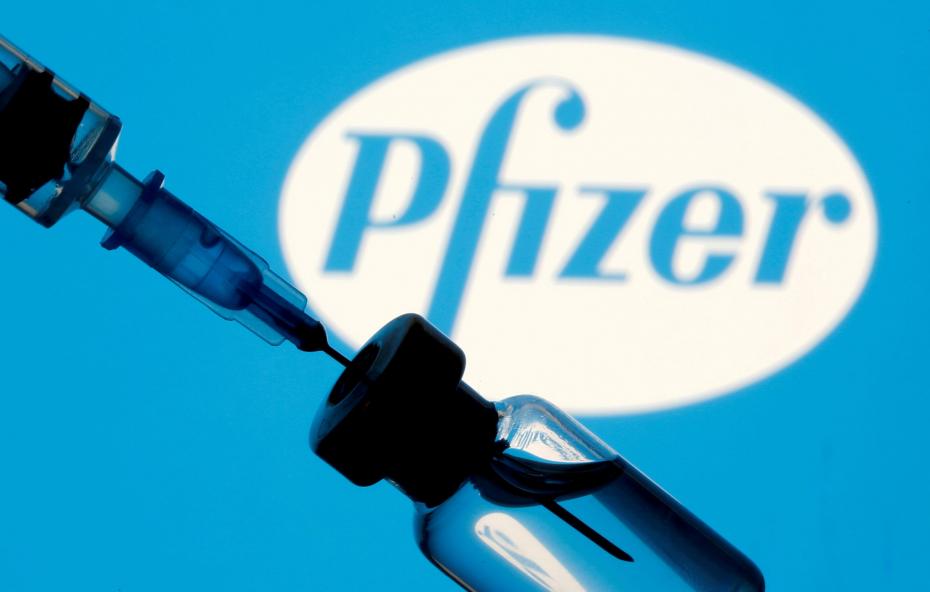 FILE PHOTO: Vial and syringe are seen in front of displayed Pfizer logo