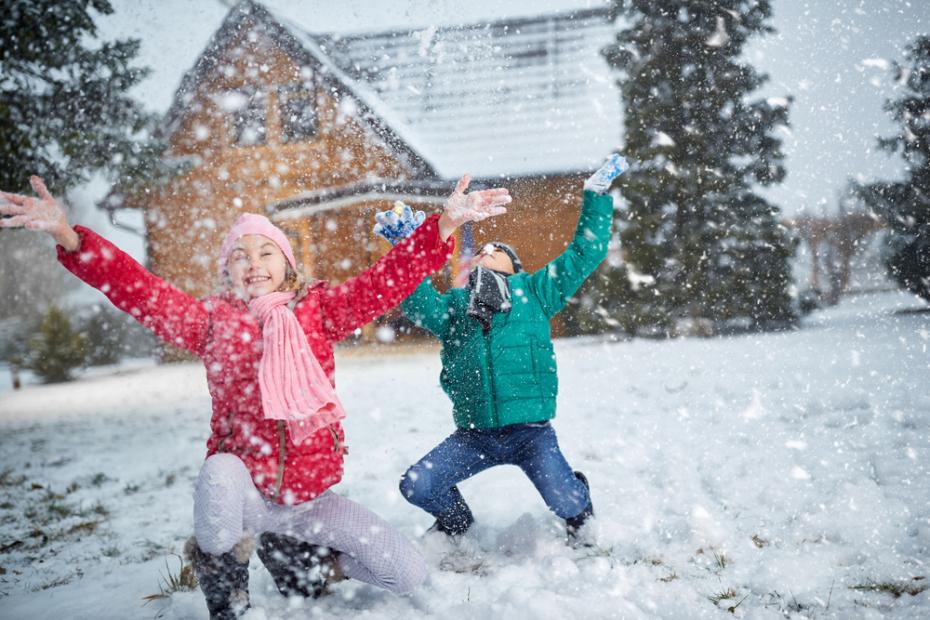 children playing on snow in winter holiday