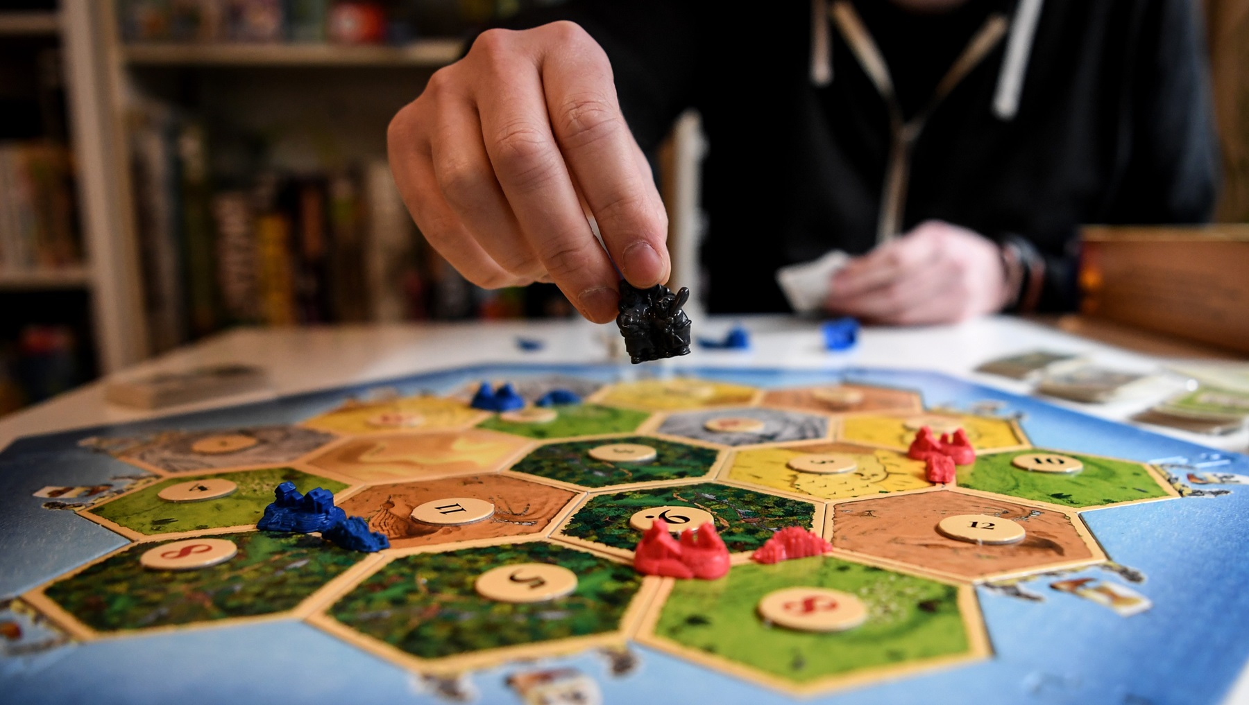 Tim Overkamp shows the game „The Settlers of Catan.”